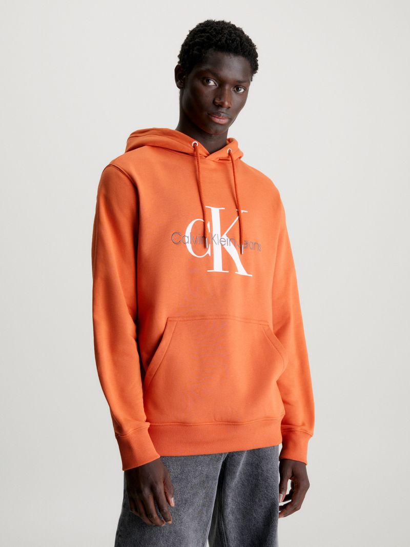 Modelo-con-poleron-naranja-Calvin-Klein-y-pantalones-negros