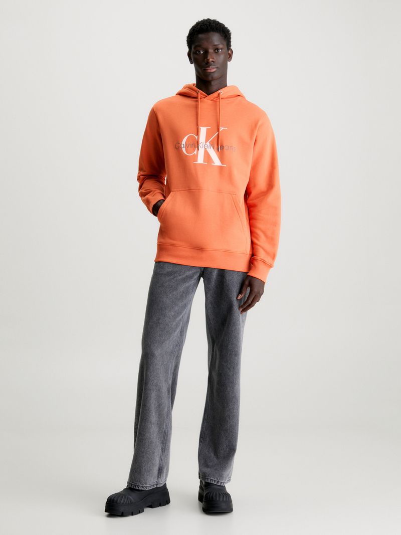 Modelo-con-poleron-naranja-Calvin-Klein-y-pantalones-negros