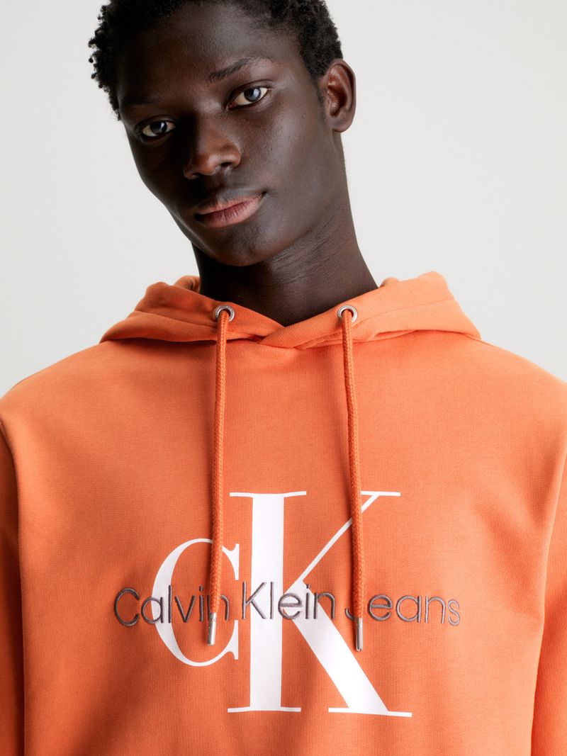 Modelo-con-poleron-naranja-Calvin-Klein-y-pantalones-negros