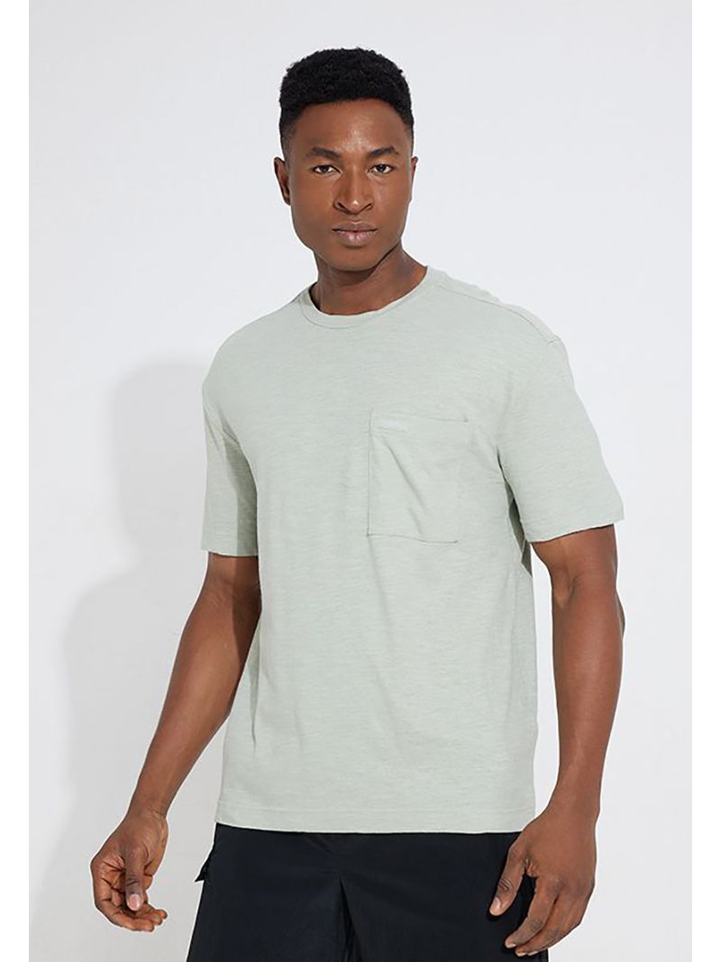 Modelo-con-polera-verde-claro-Calvin-Klein-y-pantalones-oscuros