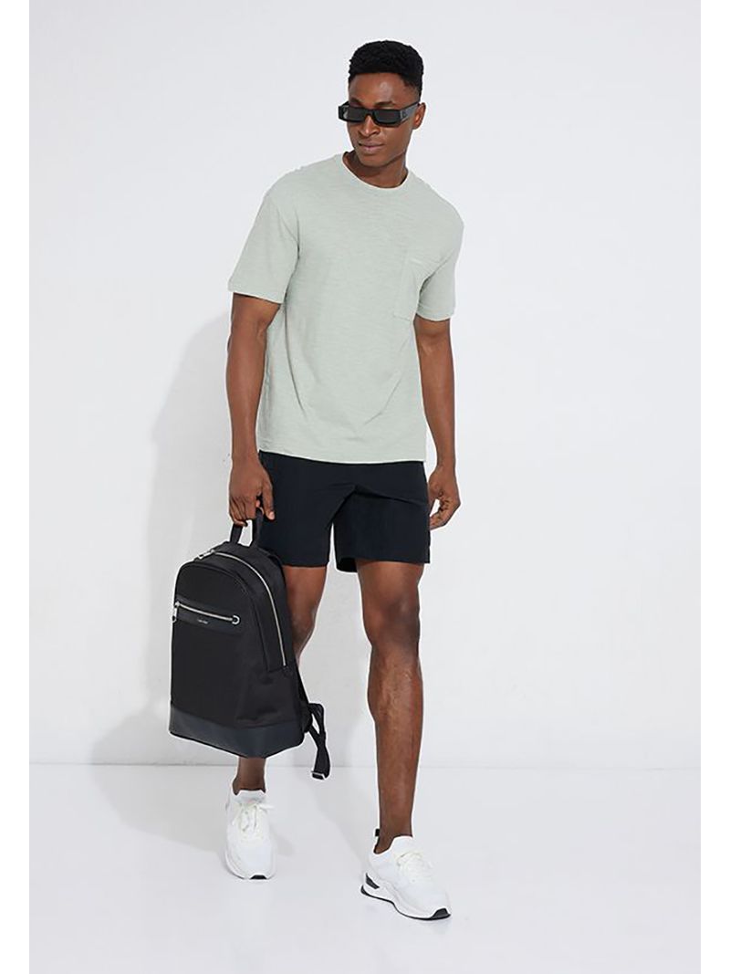 Modelo-con-polera-verde-claro-Calvin-Klein-y-pantalones-oscuros