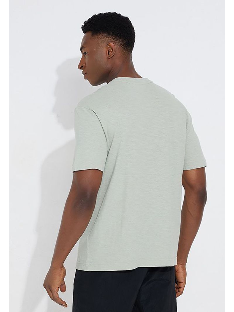 Modelo-con-polera-verde-claro-Calvin-Klein-y-pantalones-oscuros