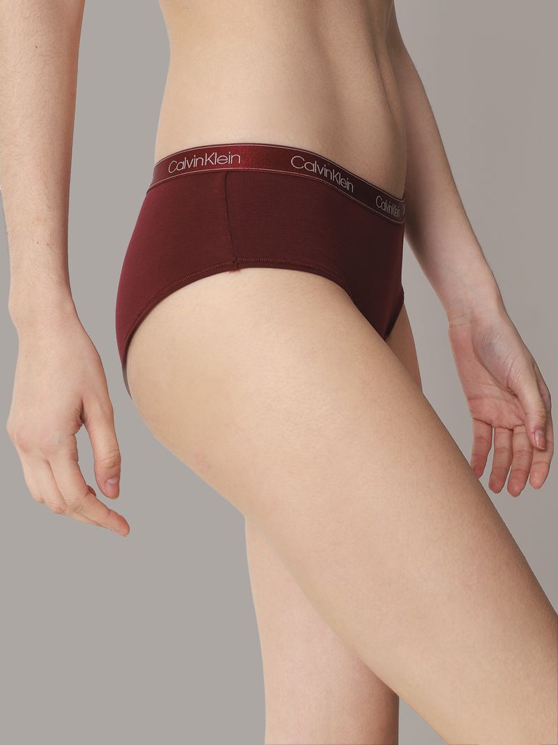 -Primer-plano-de-una-mujer-usando-calzon-Calvin-Klein-color-burdeos-con-una-banda-elastica-del-mismo-tono-y-logo-en-letras-plateadas