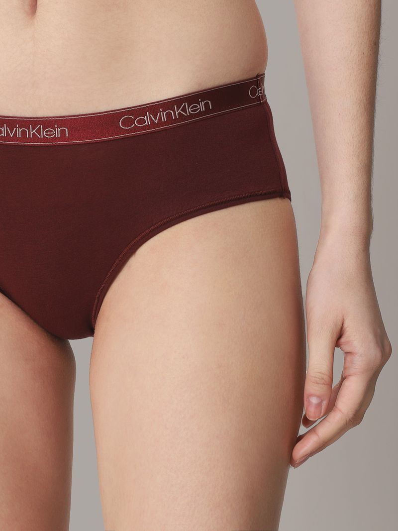 -Primer-plano-de-una-mujer-usando-calzon-Calvin-Klein-color-burdeos-con-una-banda-elastica-del-mismo-tono-y-logo-en-letras-plateadas