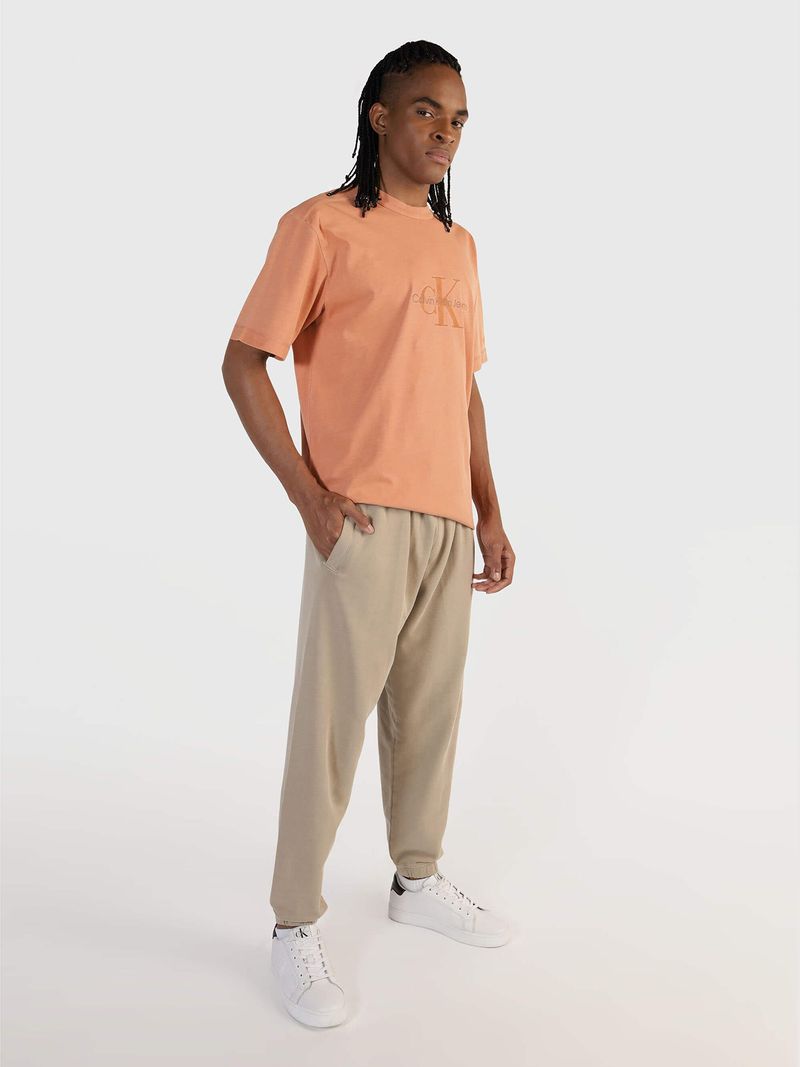 Modelo-con-polera-color-durazno-Calvin-Klein-Jeans-y-pantalones-beige