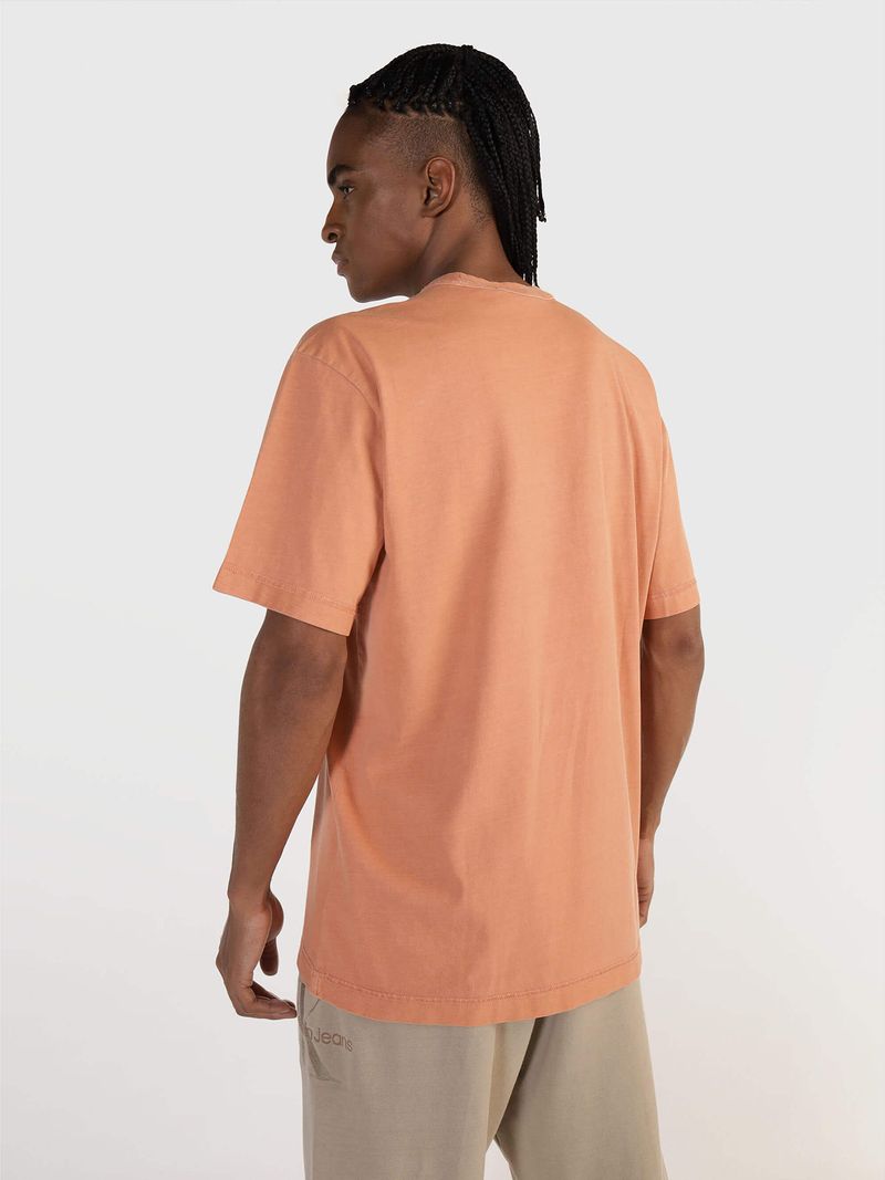 Modelo-con-polera-color-durazno-Calvin-Klein-Jeans-y-pantalones-beige