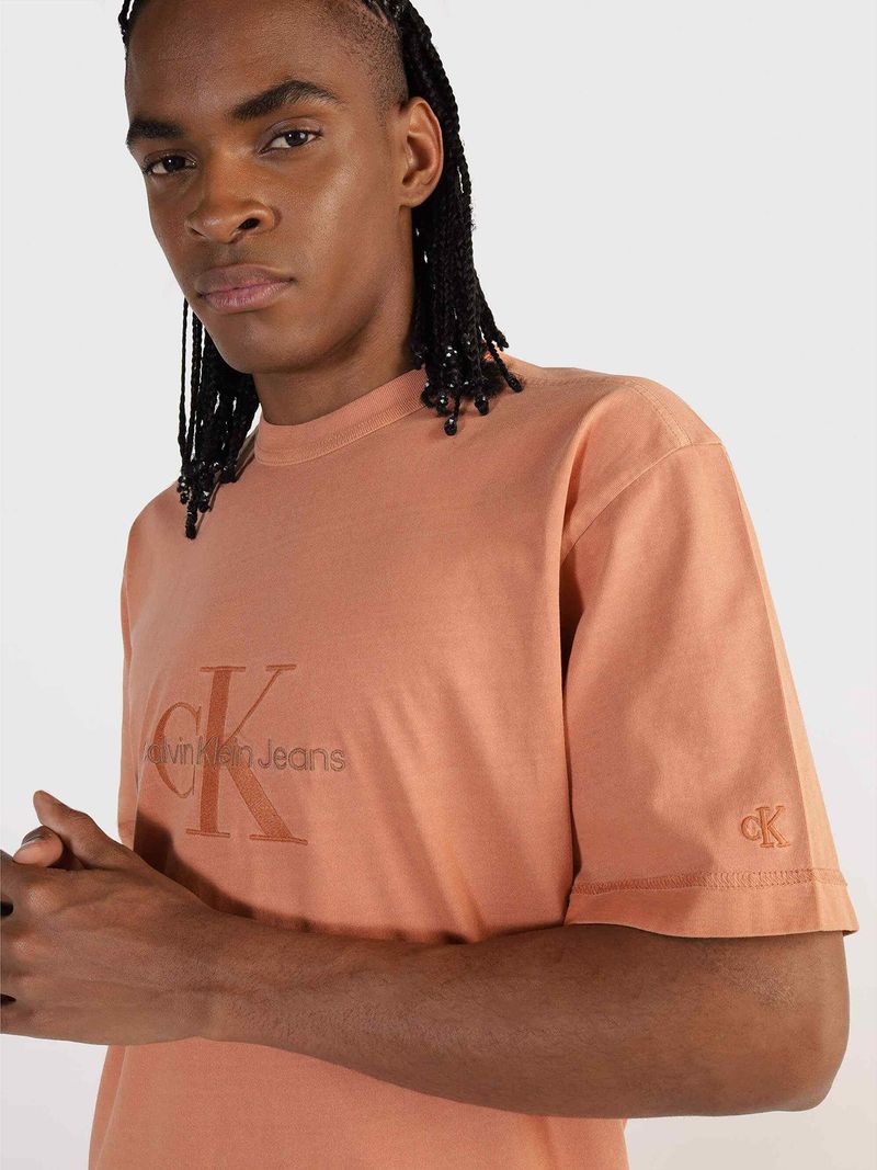 Modelo-con-polera-color-durazno-Calvin-Klein-Jeans-y-pantalones-beige