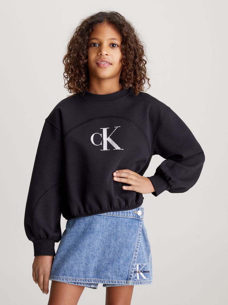 Niña-con-poleron-negro-Calvin-Klein-y-falda-de-mezclilla-azul