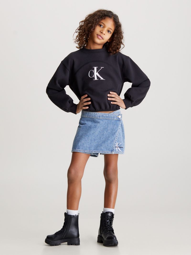 Niña-con-poleron-negro-Calvin-Klein-y-falda-de-mezclilla-azul