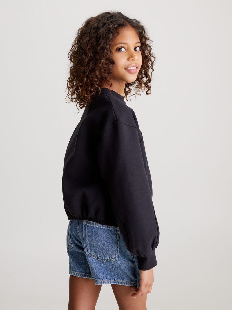 Niña-con-poleron-negro-Calvin-Klein-y-falda-de-mezclilla-azul