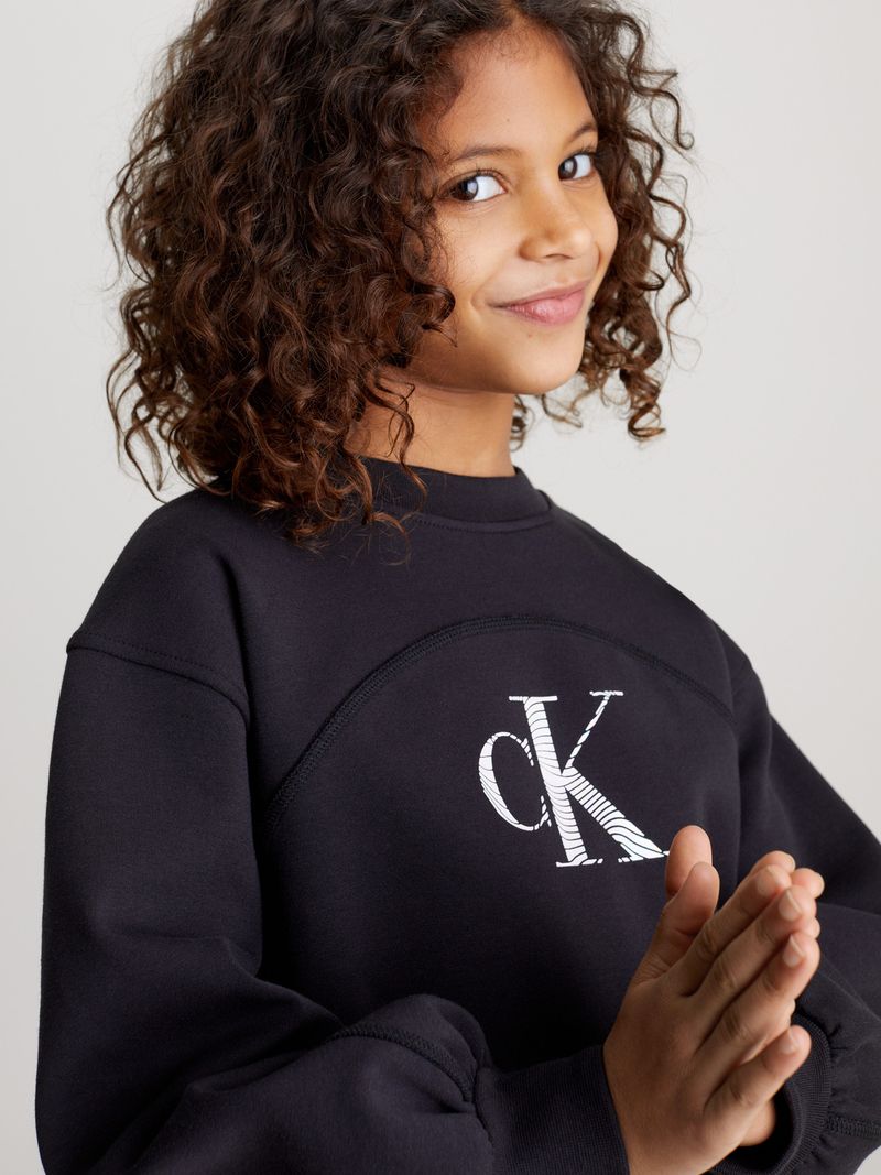 Niña-con-poleron-negro-Calvin-Klein-y-falda-de-mezclilla-azul