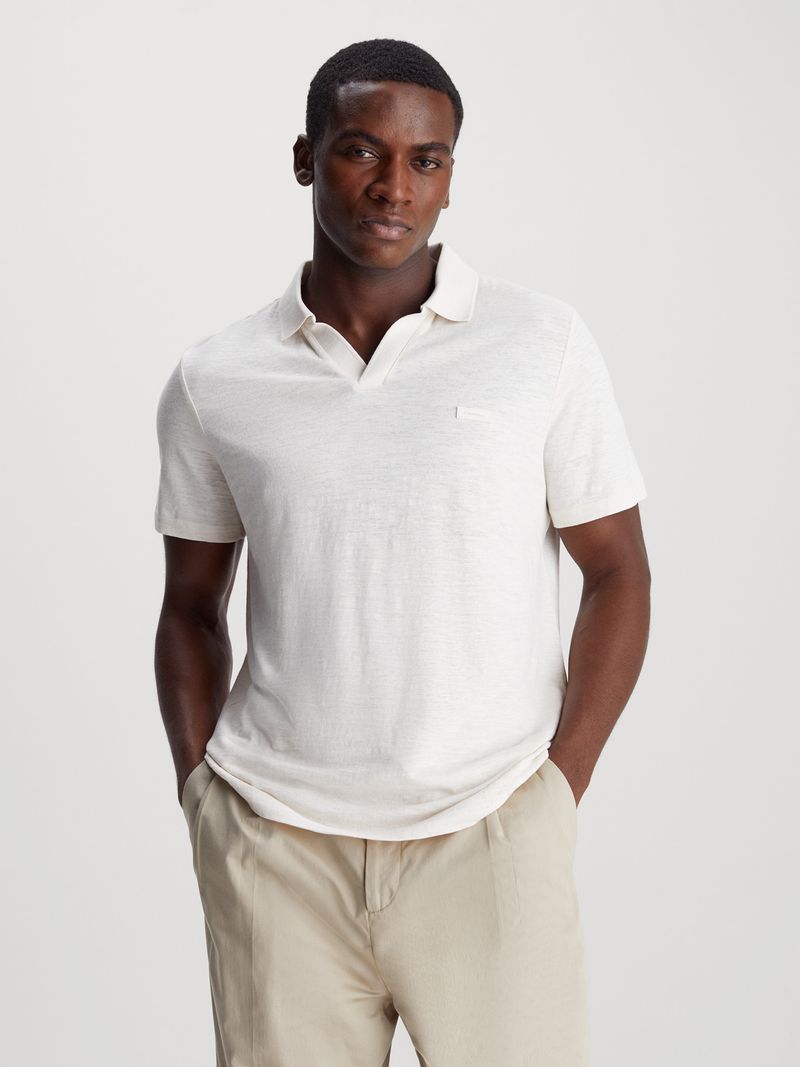 Modelo-vistiendo-polo-blanco-Calvin-Klein-y-pantalones-beige