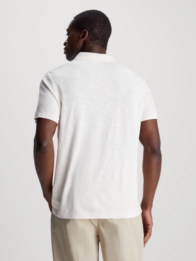 Modelo-vistiendo-polo-blanco-Calvin-Klein-y-pantalones-beige
