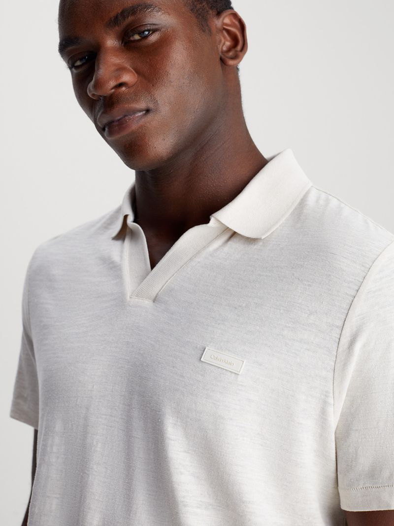 Modelo-vistiendo-polo-blanco-Calvin-Klein-y-pantalones-beige