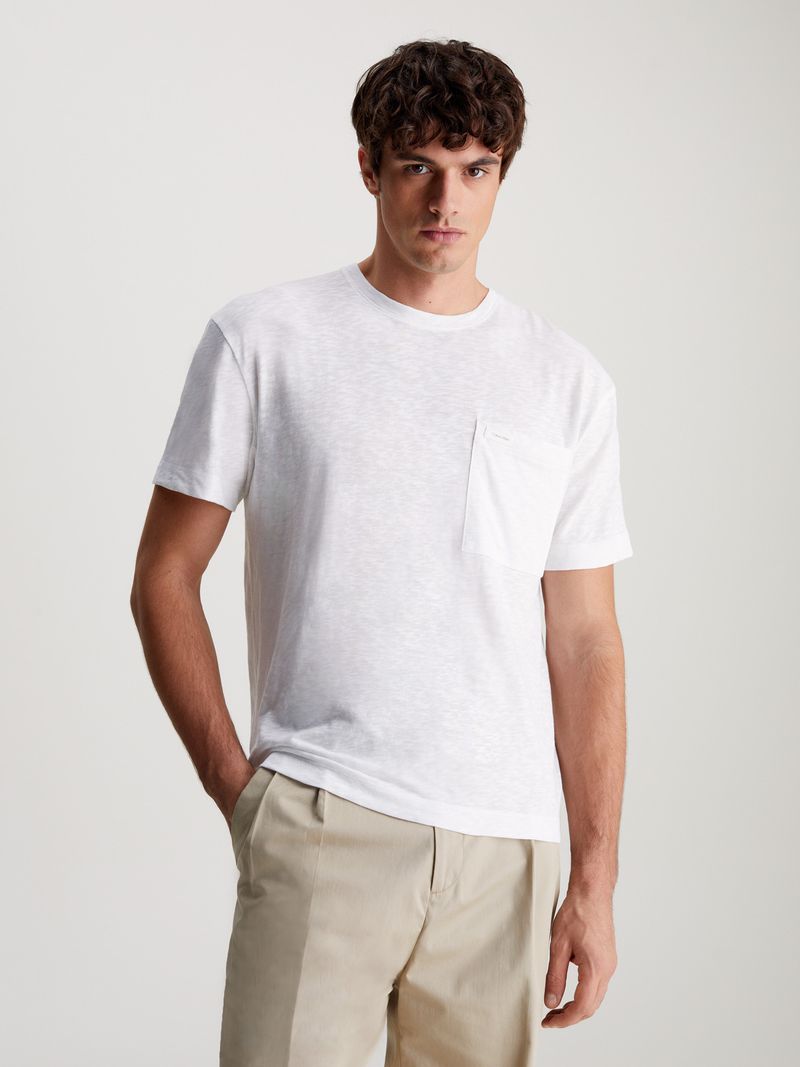 Modelo-con-polera-blanca-Calvin-Klein-y-pantalones-beige