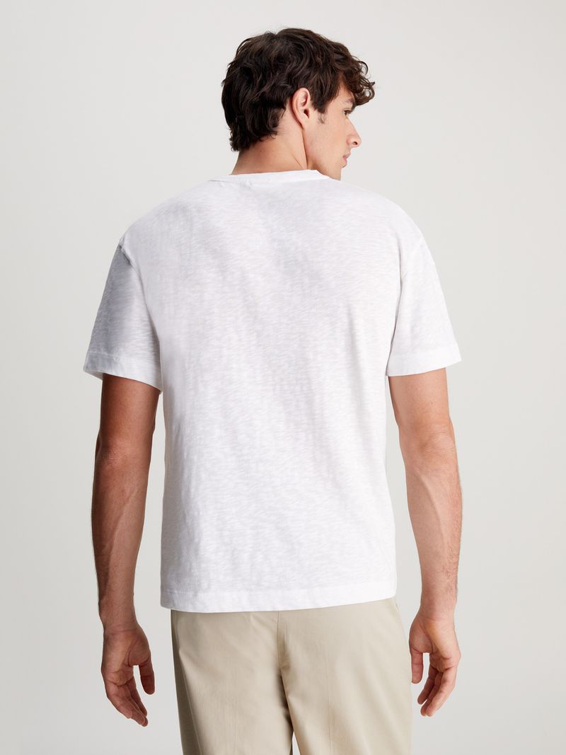 Modelo-con-polera-blanca-Calvin-Klein-y-pantalones-beige