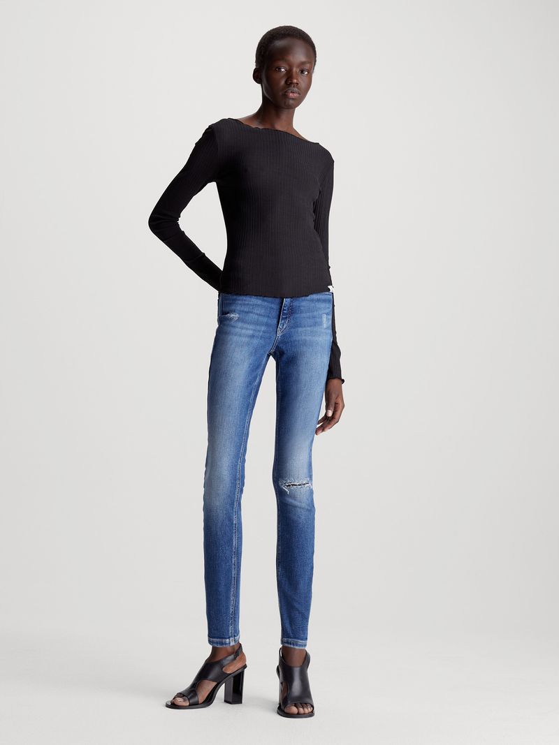 Modelo-con-jeans-azul-marino-tipo-Slim-desgaste-rodilla-Calvin-Klein