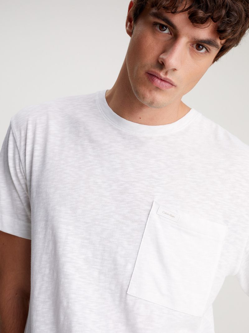Modelo-con-polera-blanca-Calvin-Klein-y-pantalones-beige