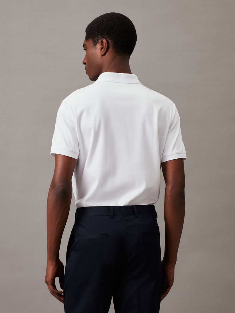 Modelo-con-polera-blanca-de-manga-corta--cierre-en-V-y-cuello-polo--y-pantalones-negros-Calvin-Klein