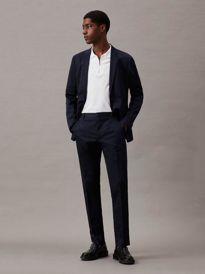Modelo-con-polera-blanca-de-manga-corta--cierre-en-V-y-cuello-polo--y-pantalones-negros-Calvin-Klein
