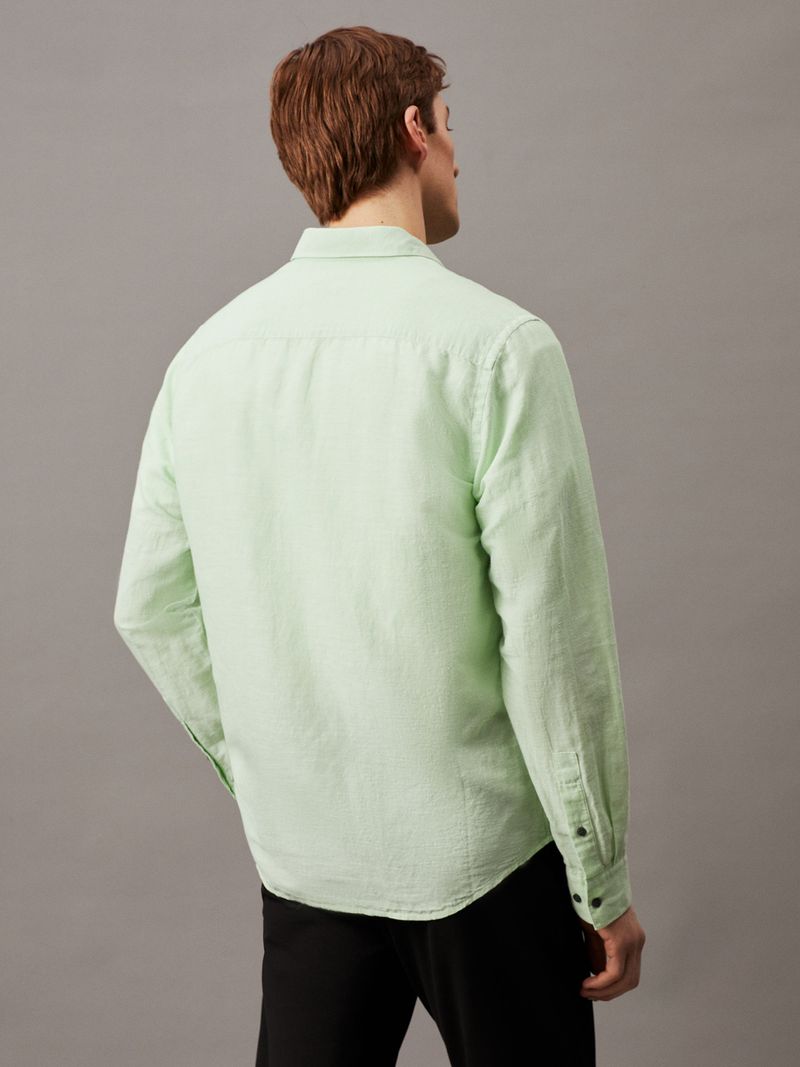 Modelo-con-camisa-verde-claro-Calvin-Klein-y-pantalones-negros
