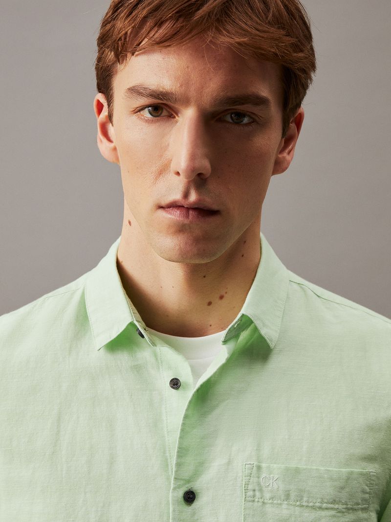Modelo-con-camisa-verde-claro-Calvin-Klein-y-pantalones-negros