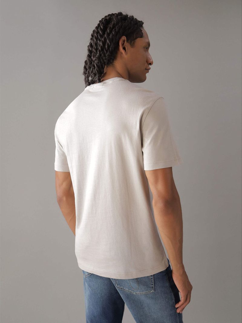 Modelo-con-polera-beige-Calvin-Klein-y-jeans-azules
