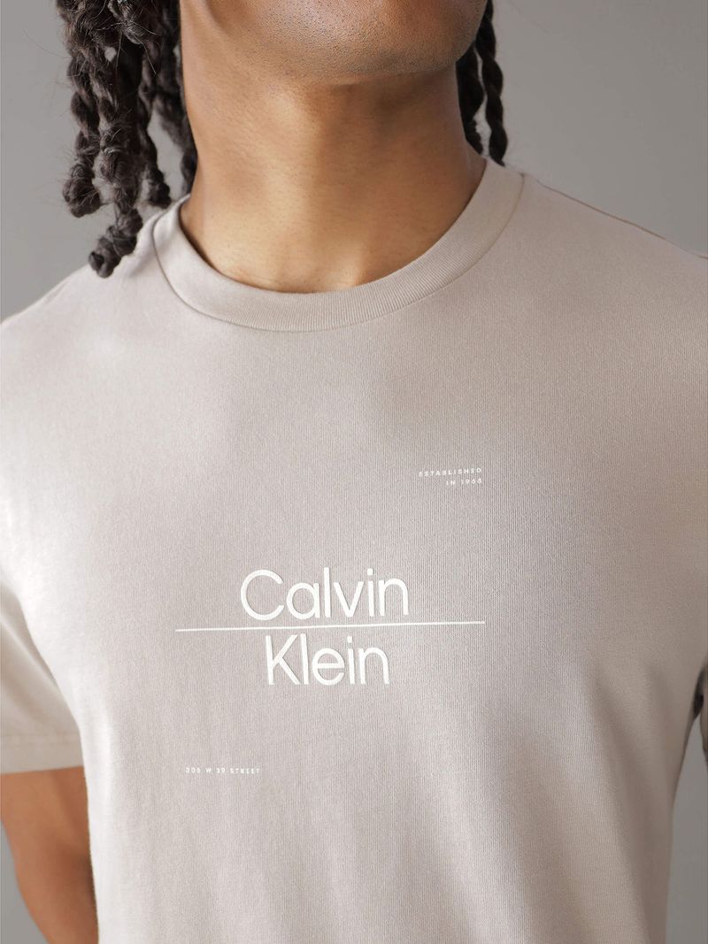 Modelo-con-polera-beige-Calvin-Klein-y-jeans-azules