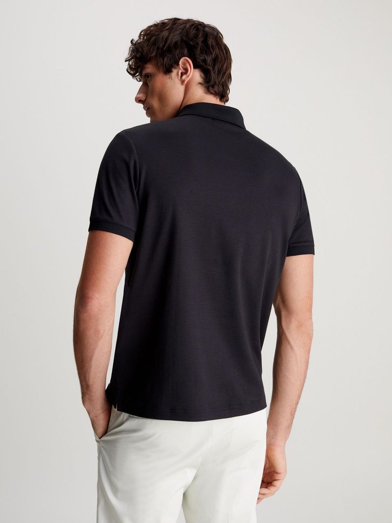 Modelo-con-polo-negro-Calvin-Klein-de-cierre-frontal-y-pantalones-claros