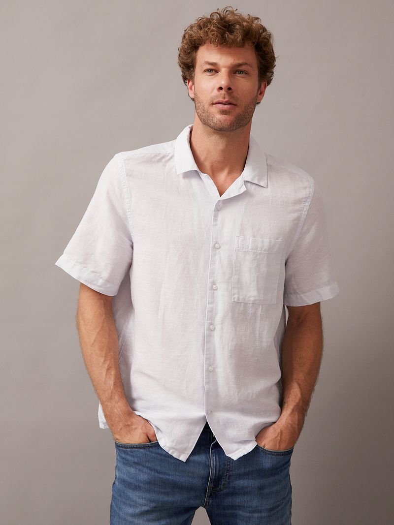 Modelo-con-camisa-blanca-manga-corta-Calvin-Klein-y-jeans-azules