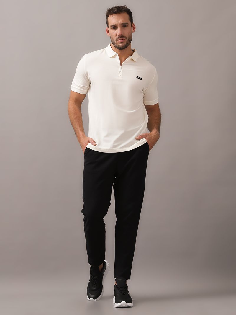 Polera-tipo-polo-color-crema-para-hombre-con-cierre-en-el-cuello-y-detalle-minimalista-de-Calvin-Klein-en-el-pecho.