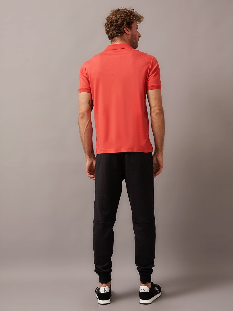 Hombre-con-polera-polo-color-rojo-con-detalle-de-Calvin-Klein-en-el-pecho