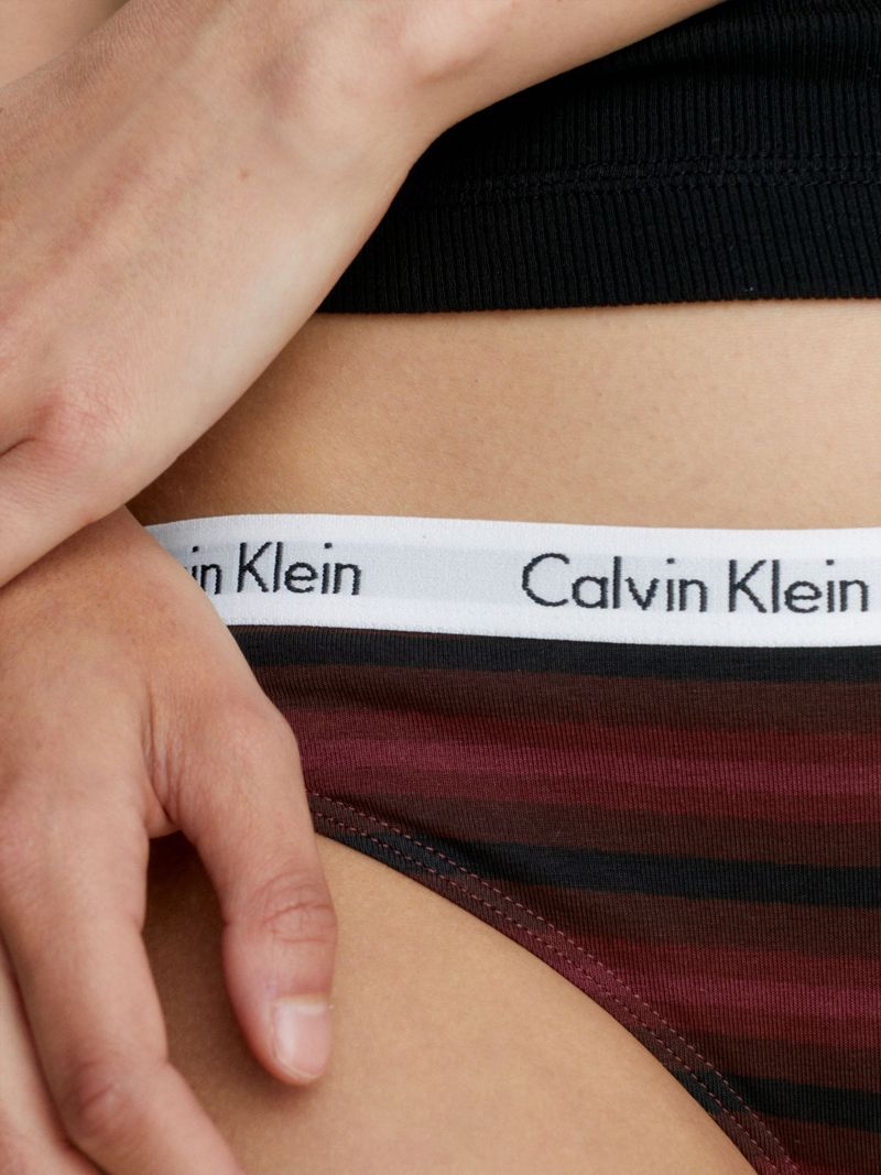 Mujer-con-calzon-Calvin-Klein-de-rayas-negras-y-burdeos-elastico-blanco-con-logo-de-la-marca.