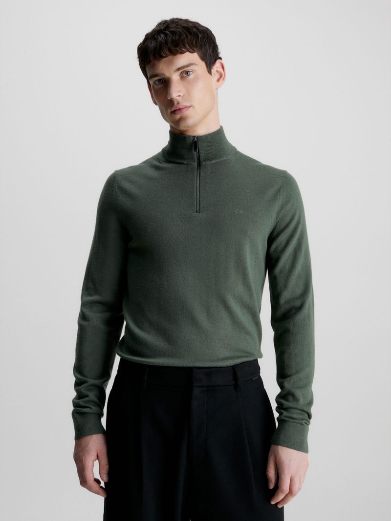 Modelo-con-sweater-verde-oscuro-de-cierre-medio-Calvin-Klein-y-pantalones-negros