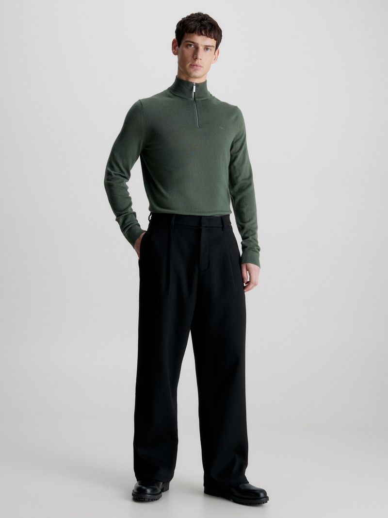 Modelo-con-sweater-verde-oscuro-de-cierre-medio-Calvin-Klein-y-pantalones-negros