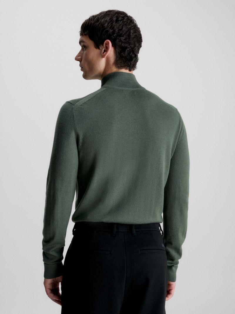 Modelo-con-sweater-verde-oscuro-de-cierre-medio-Calvin-Klein-y-pantalones-negros