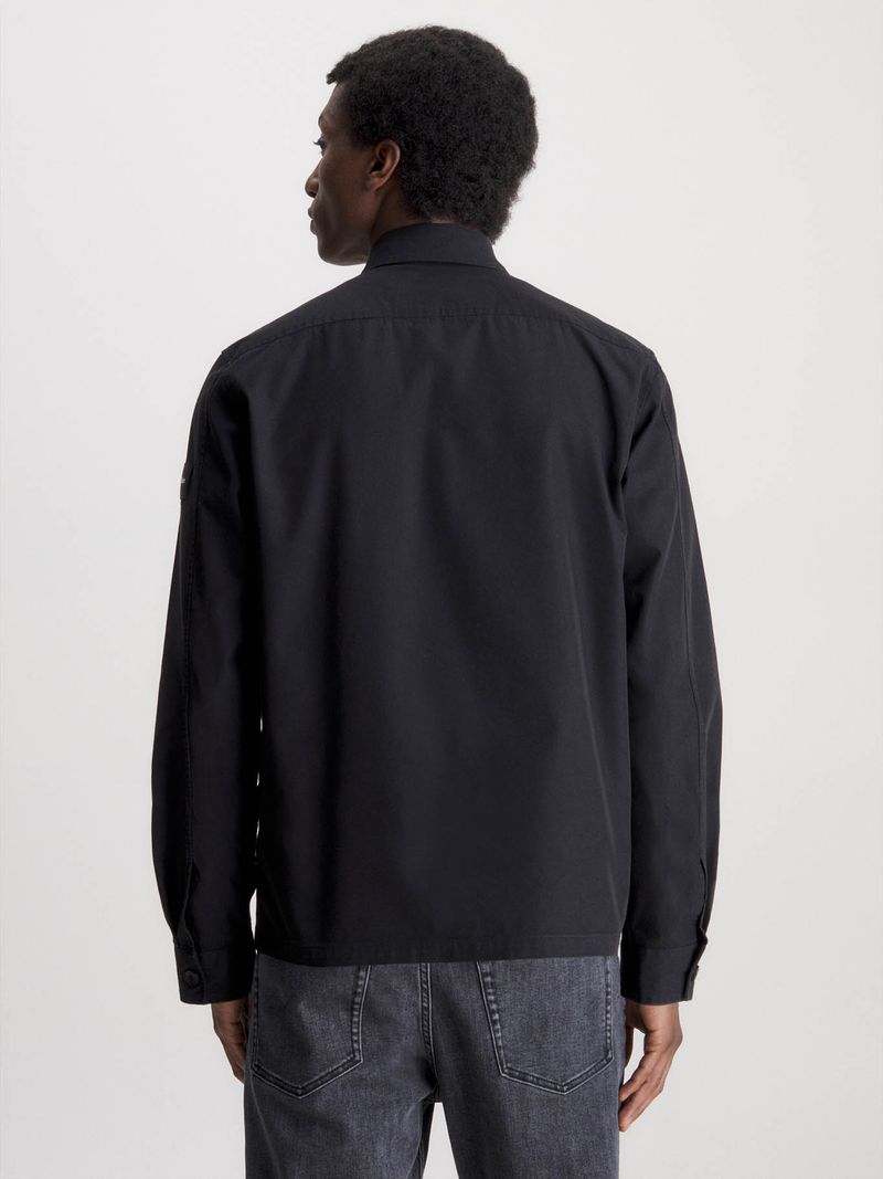 Modelo-con-sobrecamisa-negra-Calvin-Klein-y-pantalones-gris-oscuro