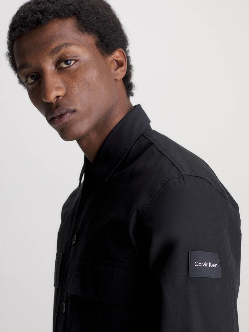 Modelo-con-sobrecamisa-negra-Calvin-Klein-y-pantalones-gris-oscuro