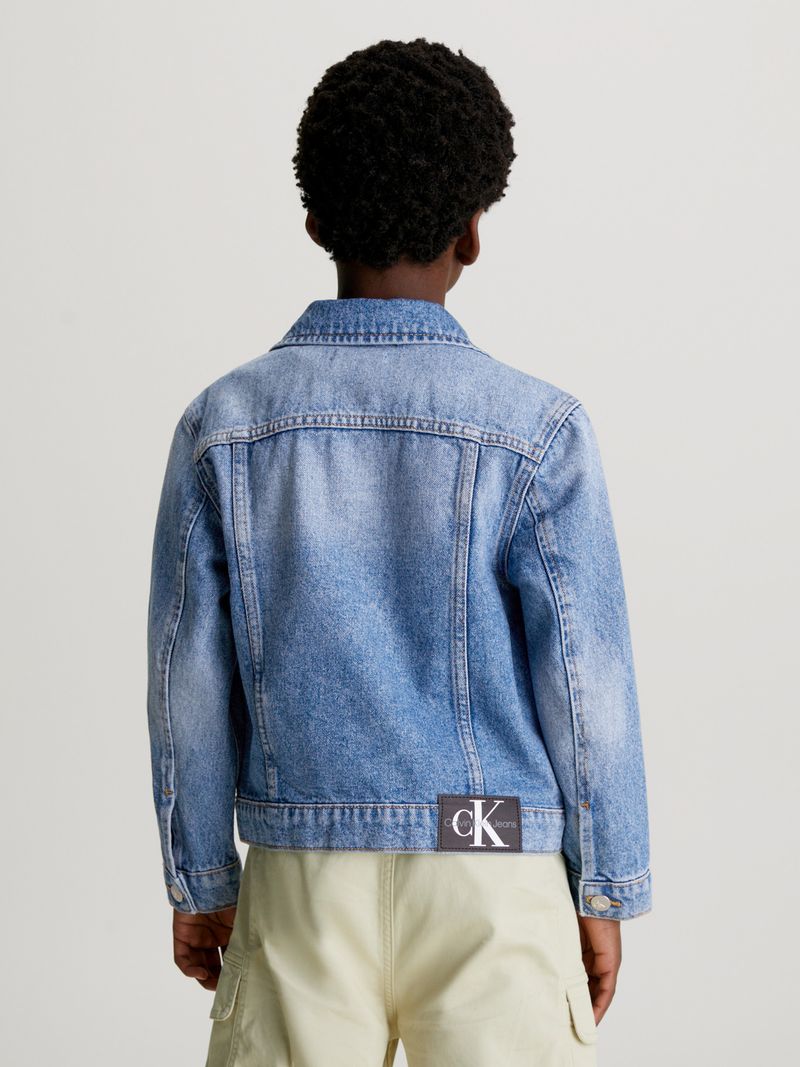 Niño-con-chaqueta-de-mezclilla-azul-Calvin-Klein-polera-blanca-y-pantalones-beige