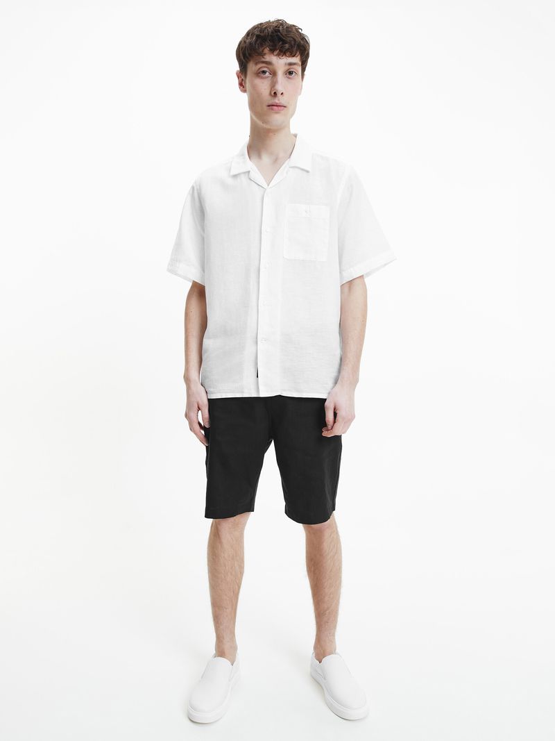 Modelo-con-camisa-manga-corta-blanca-Calvin-Klein-y-pantalones-oscuros