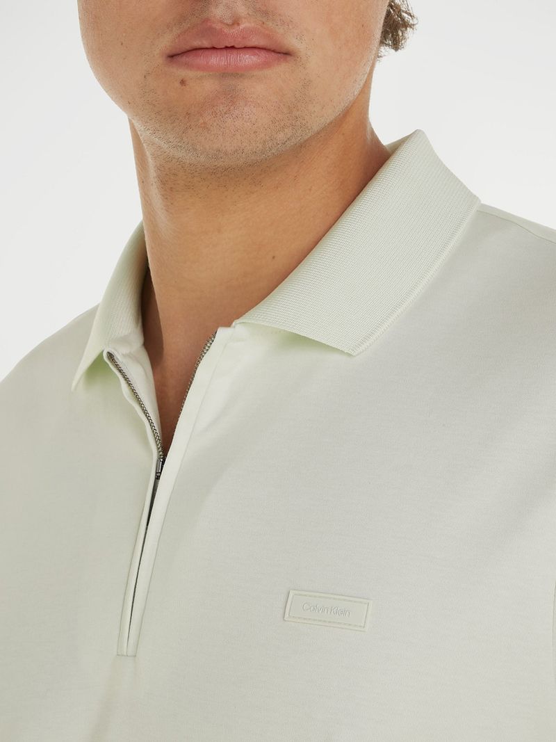 Polera-tipo-polo-color-crema-pistacho-para-hombre-con-cierre-en-el-cuello-y-detalle-minimalista-de-Calvin-Klein-en-el-pecho.