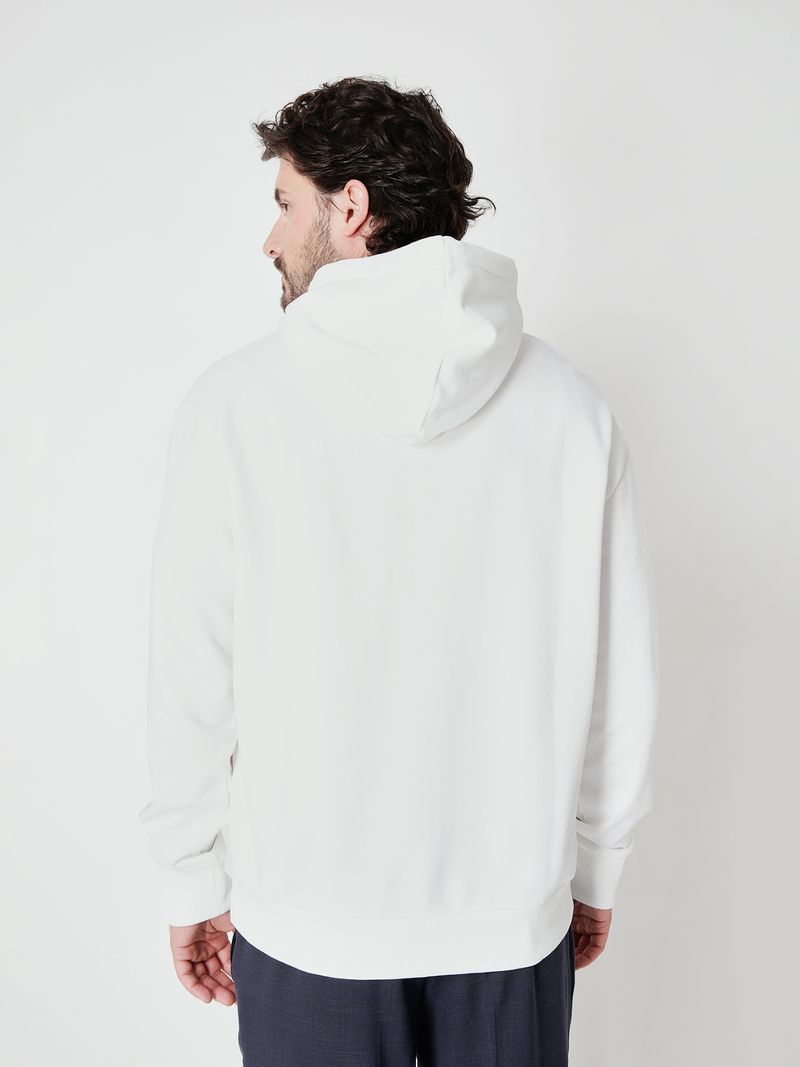 Modelo-con-poleron-blanco-Calvin-Klein-estampado-y-pantalones-oscuros