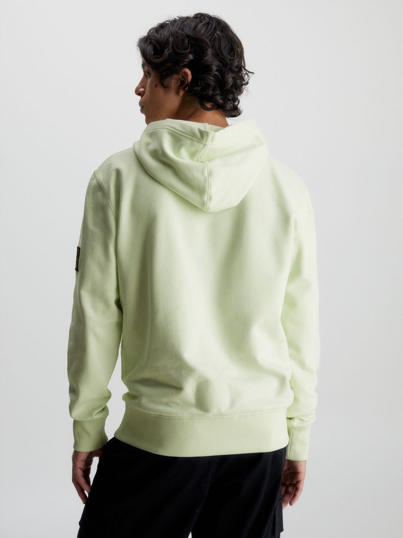 Modelo-con-poleron-verde-claro-Calvin-Klein-y-bolsillo-canguro