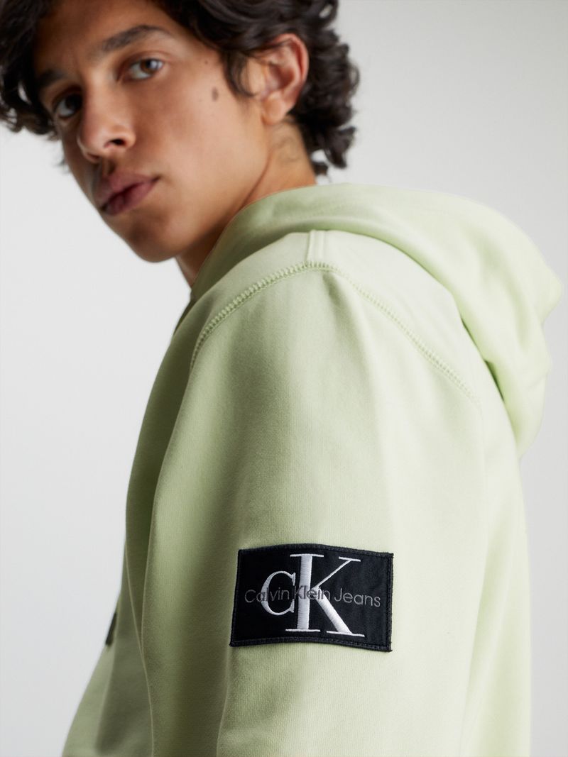 Modelo-con-poleron-verde-claro-Calvin-Klein-y-bolsillo-canguro