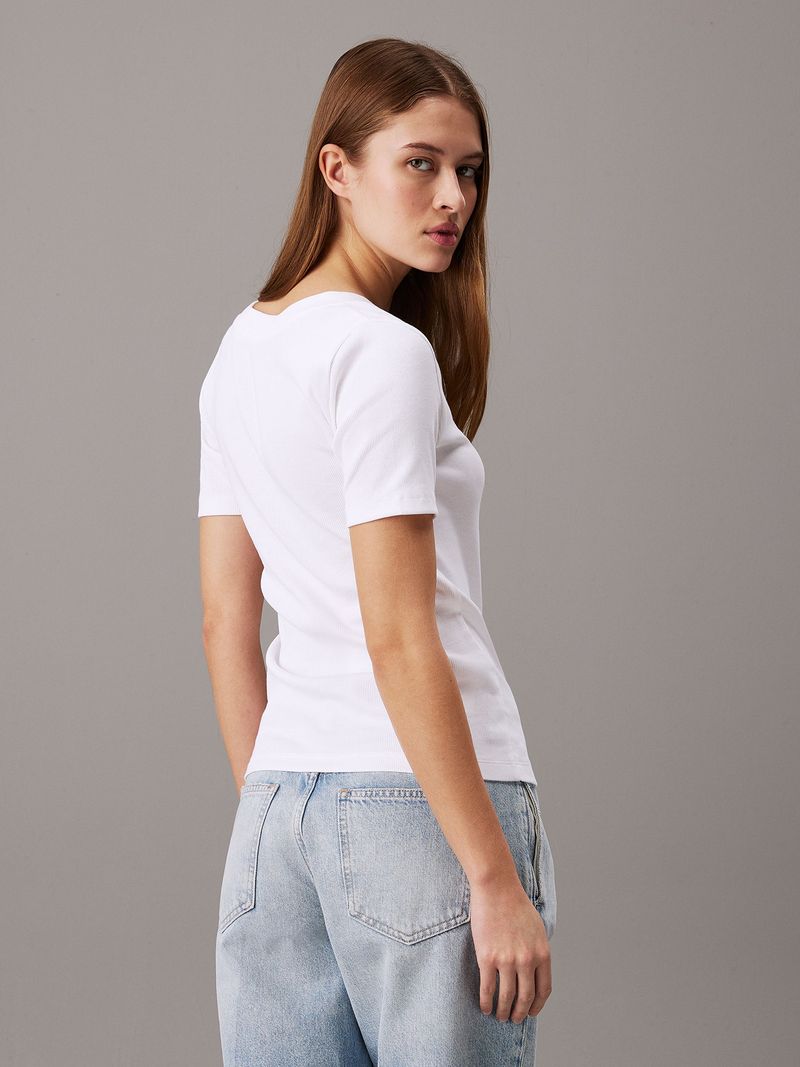 Modelo-con-polera-blanca-de-cuello-en-V-Calvin-Klein-y-jeans-claros