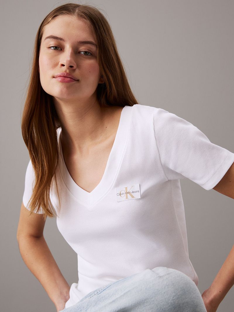 Modelo-con-polera-blanca-de-cuello-en-V-Calvin-Klein-y-jeans-claros