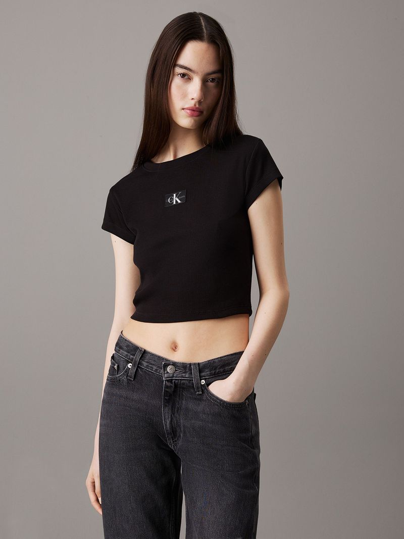 Modelo-con-polera-negra-corta-Calvin-Klein-y-pantalones-gris-oscuro