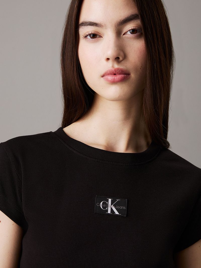 Modelo-con-polera-negra-corta-Calvin-Klein-y-pantalones-gris-oscuro