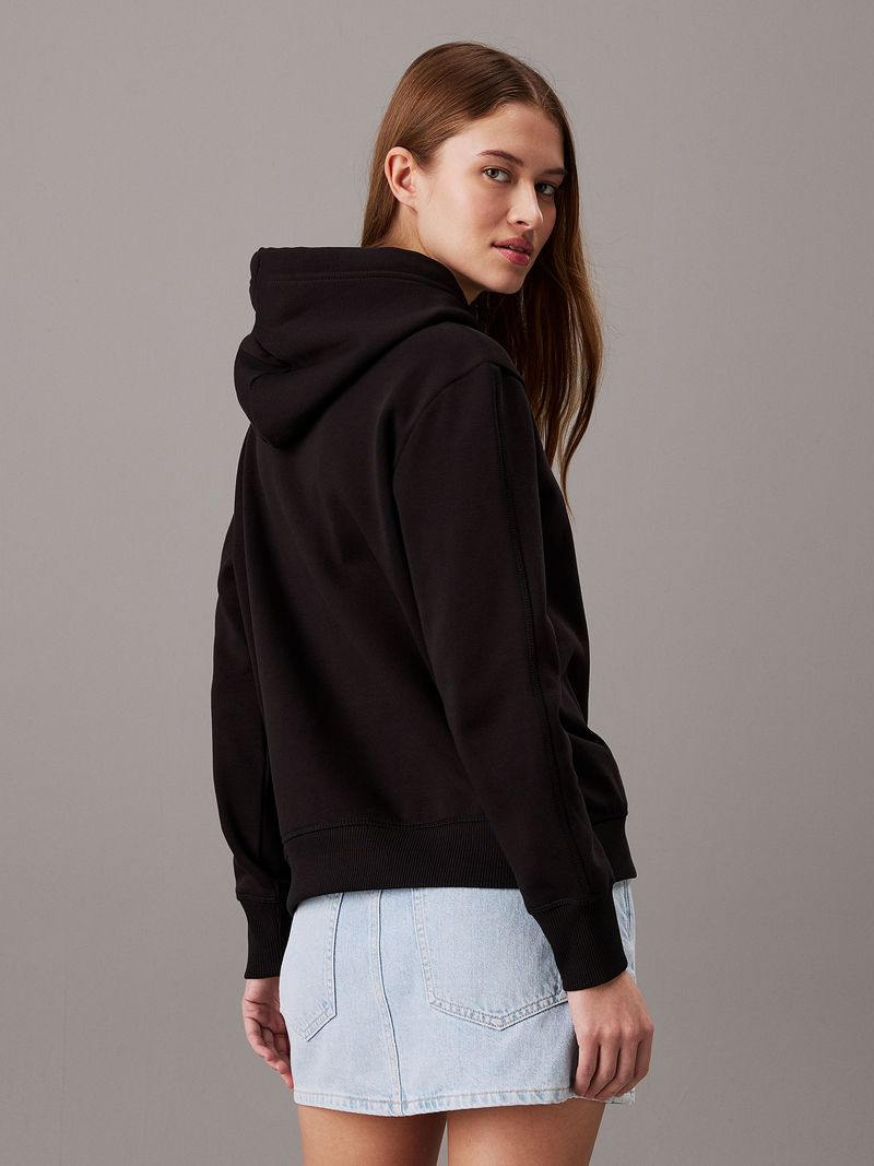 Modelo-con-poleron-negro-Calvin-Klein-y-falda-de-mezclilla-clara