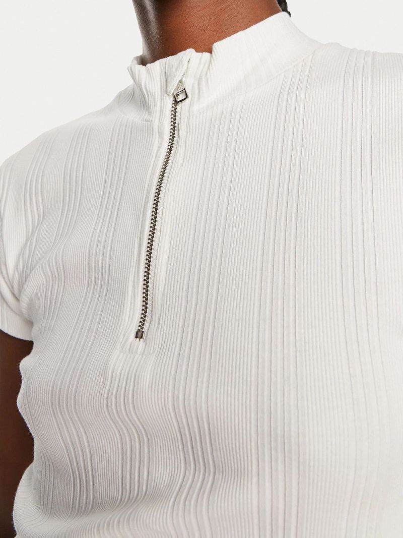 Modelo-con-polera-blanca-de-cuello-corto-Calvin-Klein-y-pantalones-negros
